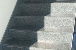 Eine moderne Außentreppe aus poliertem Granit mit minimalistischem Design.
