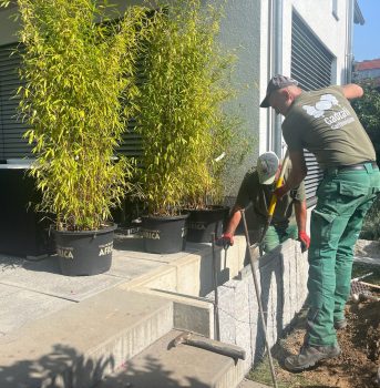 Gartenarbeiter bei der Verlegung einer neuen Beetbegrenzung.