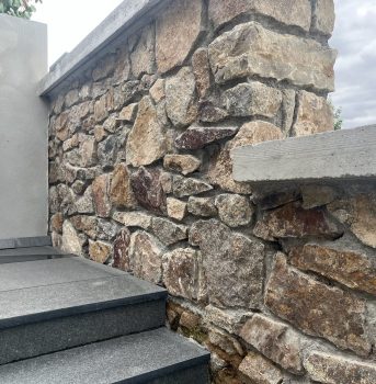 Rustikale Natursteinmauer mit sauber verarbeiteten Steinen.