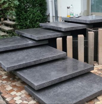 Stylische Treppenstufen aus dunklem Naturstein mit moderner Gestaltung.